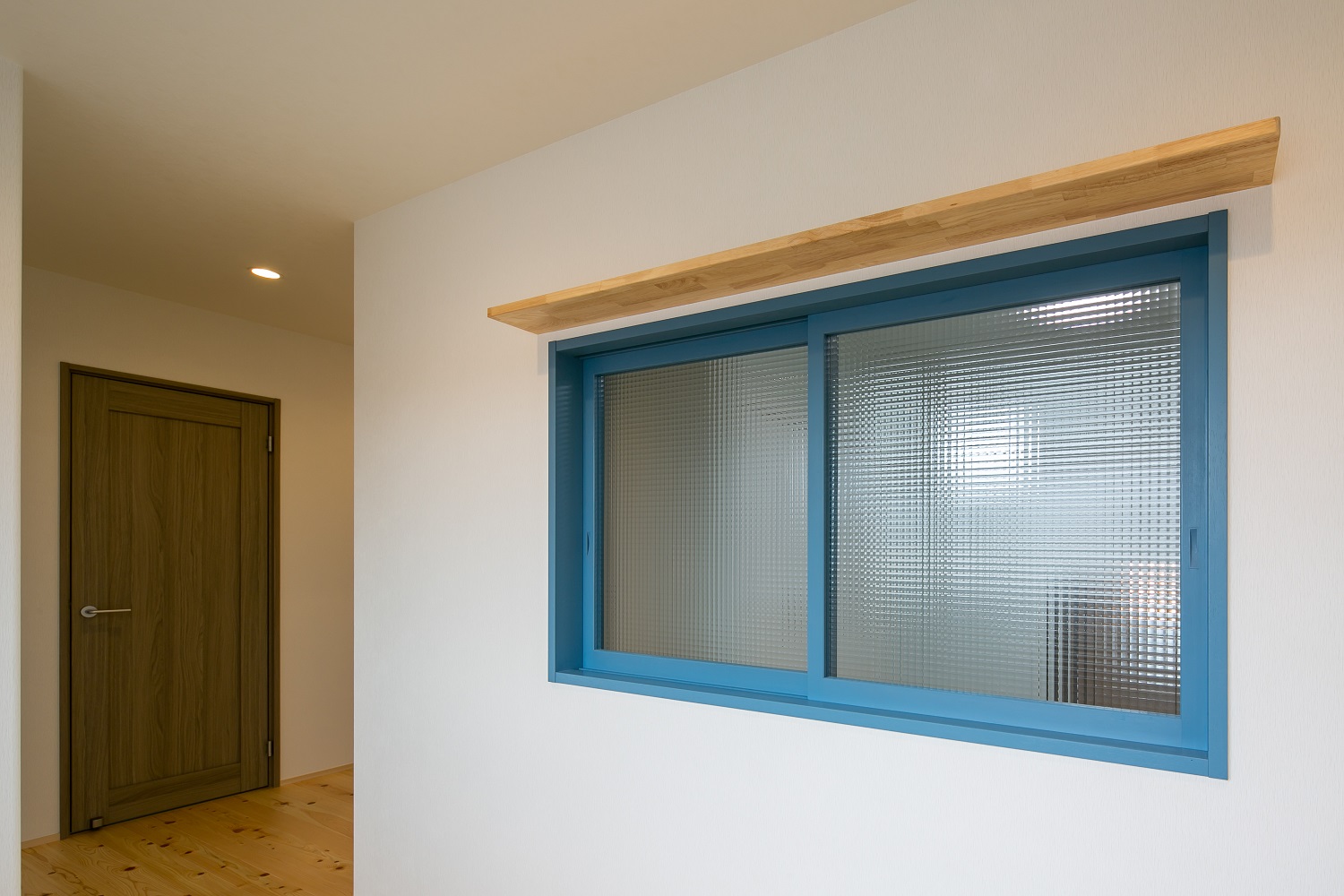 ブルーの木枠にチェッカーガラスの室内窓、光と風を取り込みます。