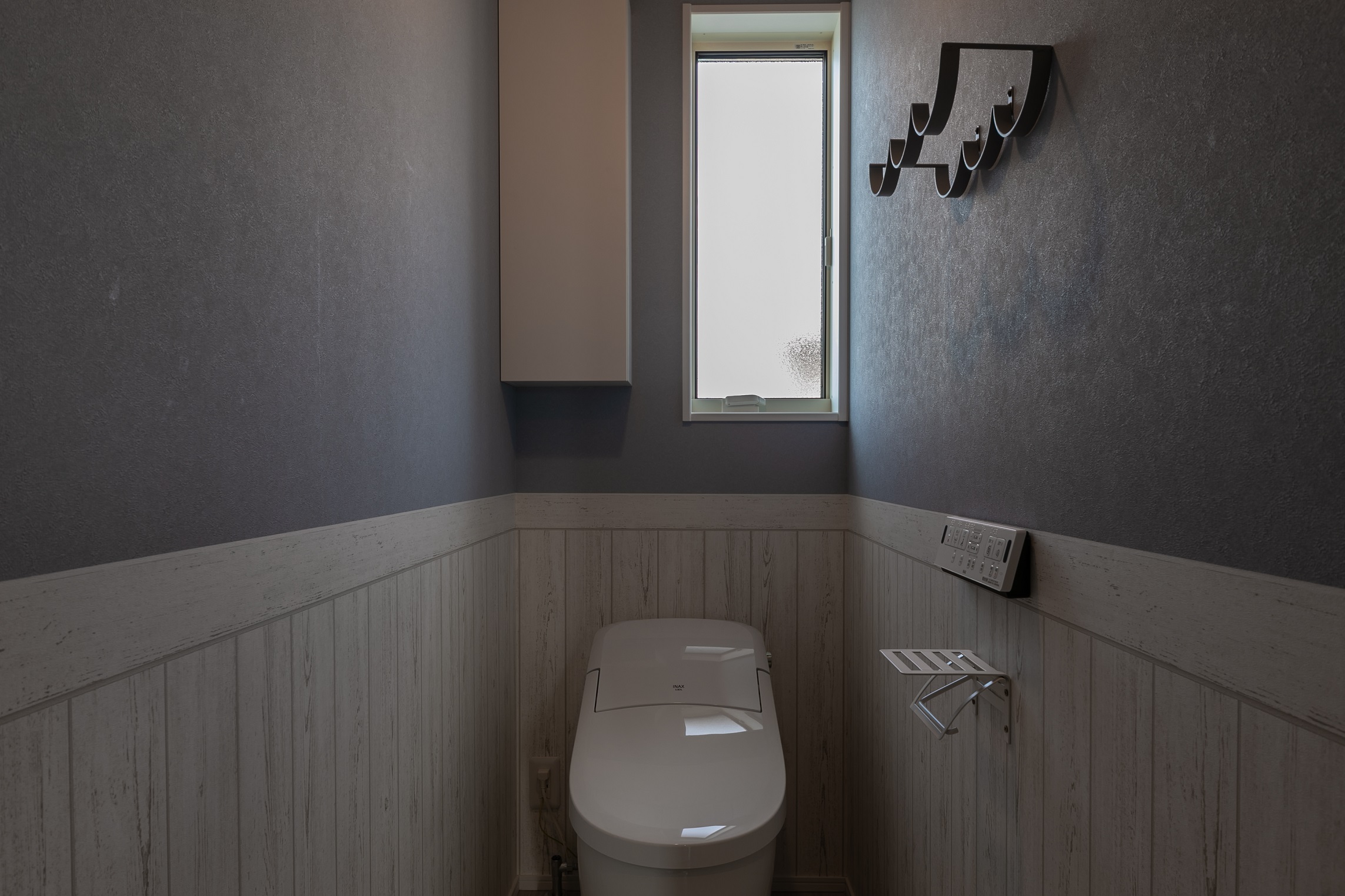 ブルーグレーと腰板風のホワイトがバランスよく、落着きのある雰囲気のトイレです。