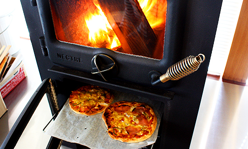 薪ストーブで料理 ピザの写真